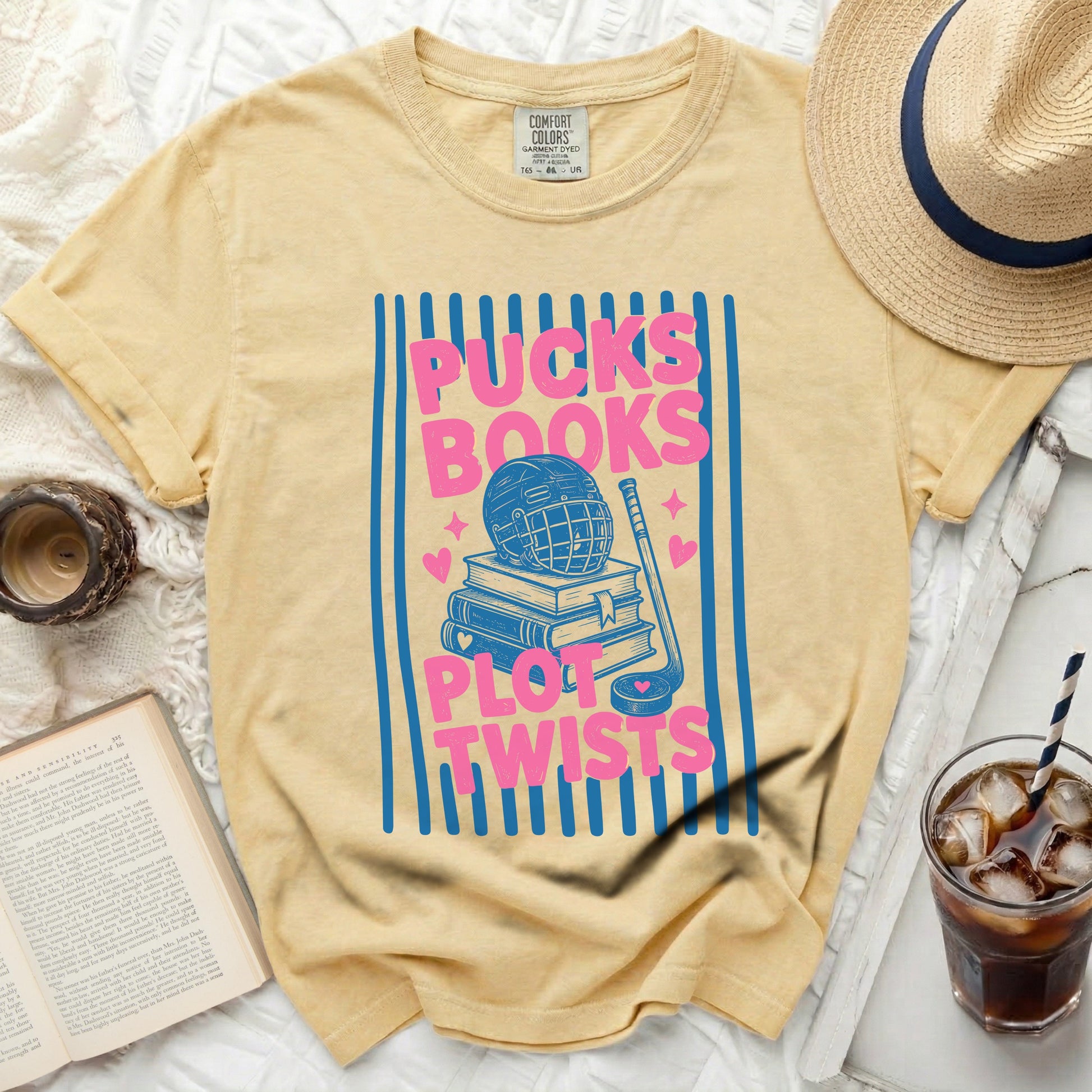 Yellow t-shirt with blue stripes, hockey gear, and "Pucks Plot Twists" text.