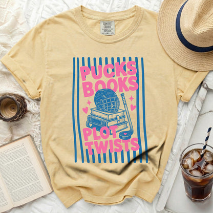 Yellow t-shirt with blue stripes, hockey gear, and "Pucks Plot Twists" text.