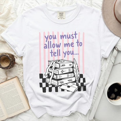 White t-shirt with text "you must allow me to tell you..." and book illustration.