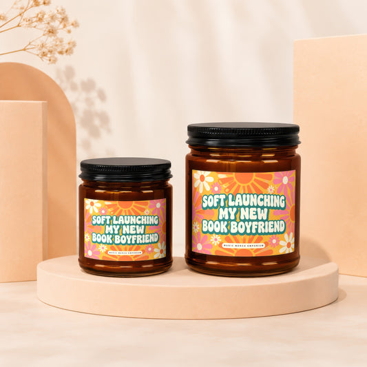 Two amber jars with black lids, featuring retro floral labels that read "Soft Launching My New Book Boyfriend."