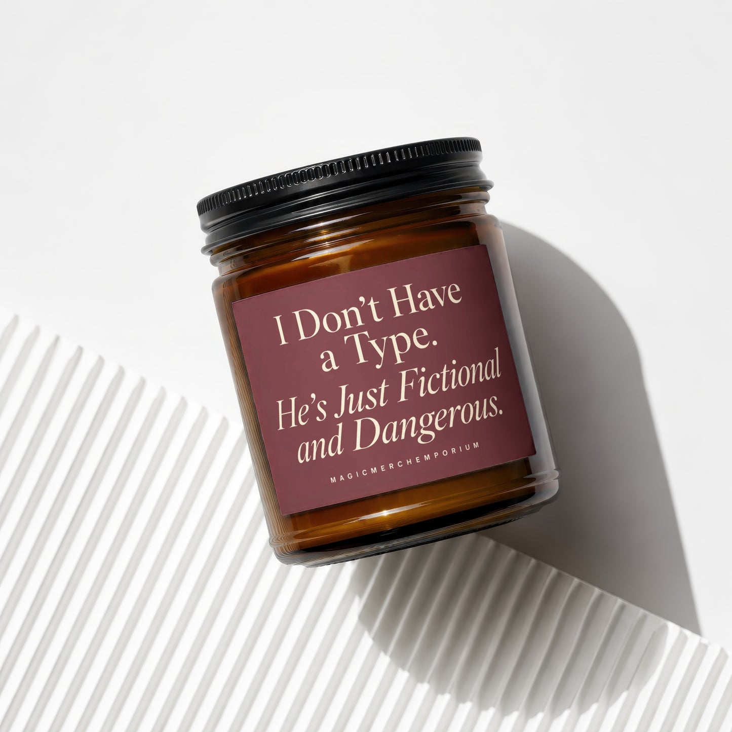 Brown glass candle with black lid and label reading "I Don't Have a Type. He's Just Fictional and Dangerous."