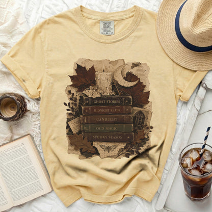 Yellow t-shirt with "Ghost Stories", "Midnight Reads", "Candlelit", "Old Magic", "Spooky Season" book graphic.