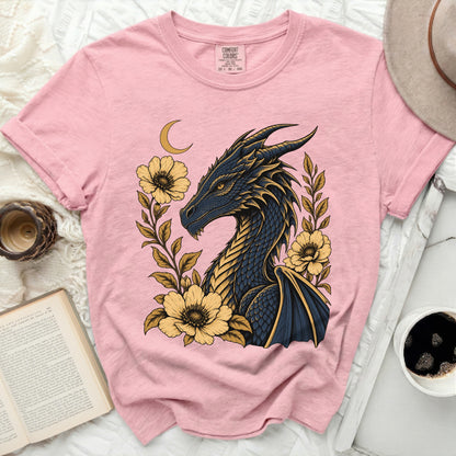 Pink t-shirt with a dark blue and gold dragon surrounded by yellow flowers and a crescent moon.