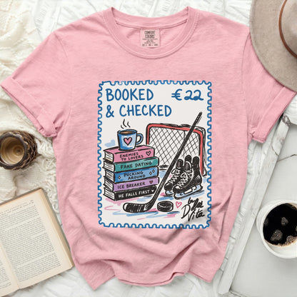 Pink t-shirt with stamp graphic of hockey gear and book titles.