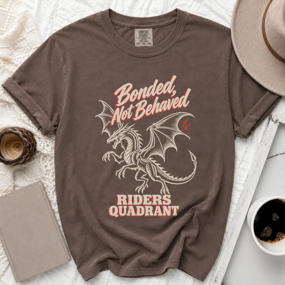 Brown t-shirt with "Bonded, Not Behaved Riders Quadrant" text and dragon graphic.