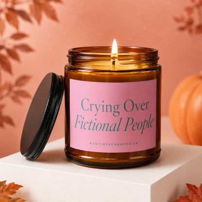 Lit candle in amber jar with pink label that reads "Crying Over Fictional People".