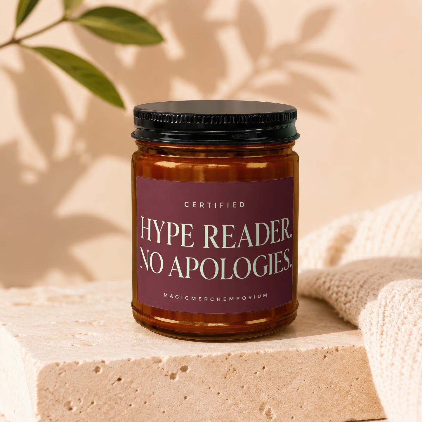 Amber jar candle with a maroon label reading "CERTIFIED HYPE READER NO APOLOGIES".