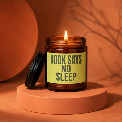 Candle with "BOOK SAYS NO SLEEP" on a yellow label.