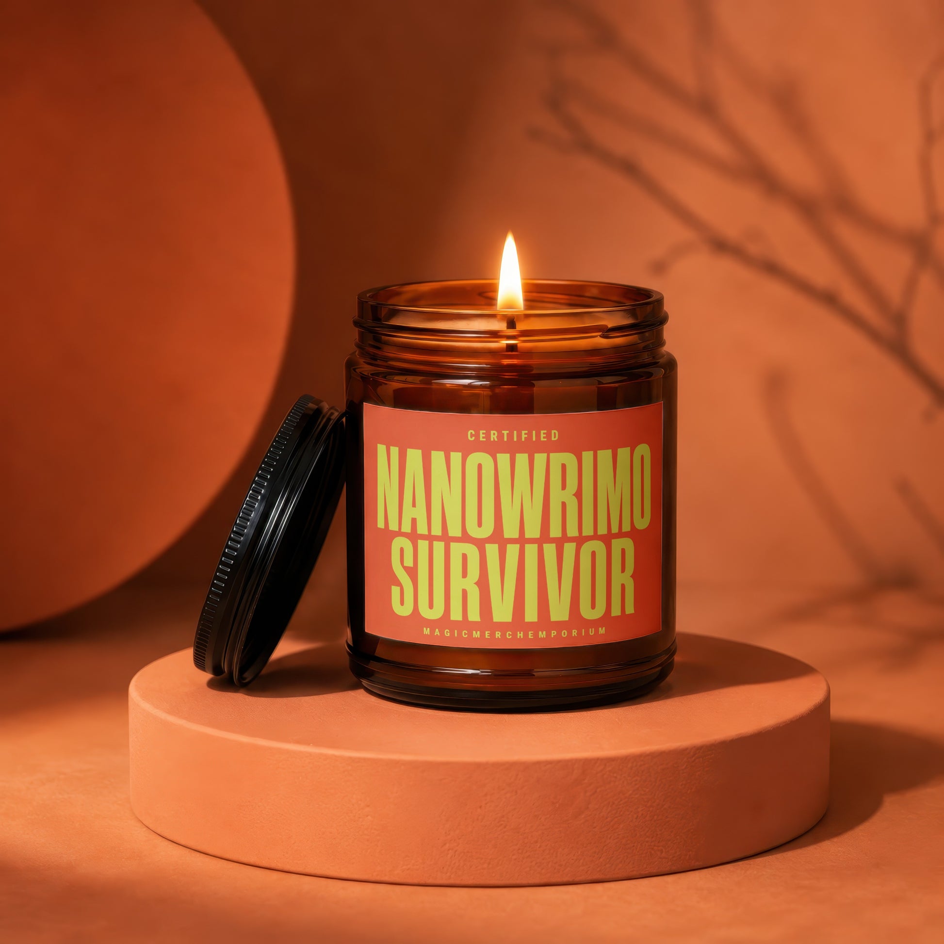 Amber jar candle with lit wick. Label reads "CERTIFIED NANOWRIMo SURVIVOR".