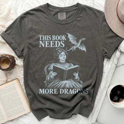 T-shirt with "This Book Needs More Dragons" text and dragon graphic.