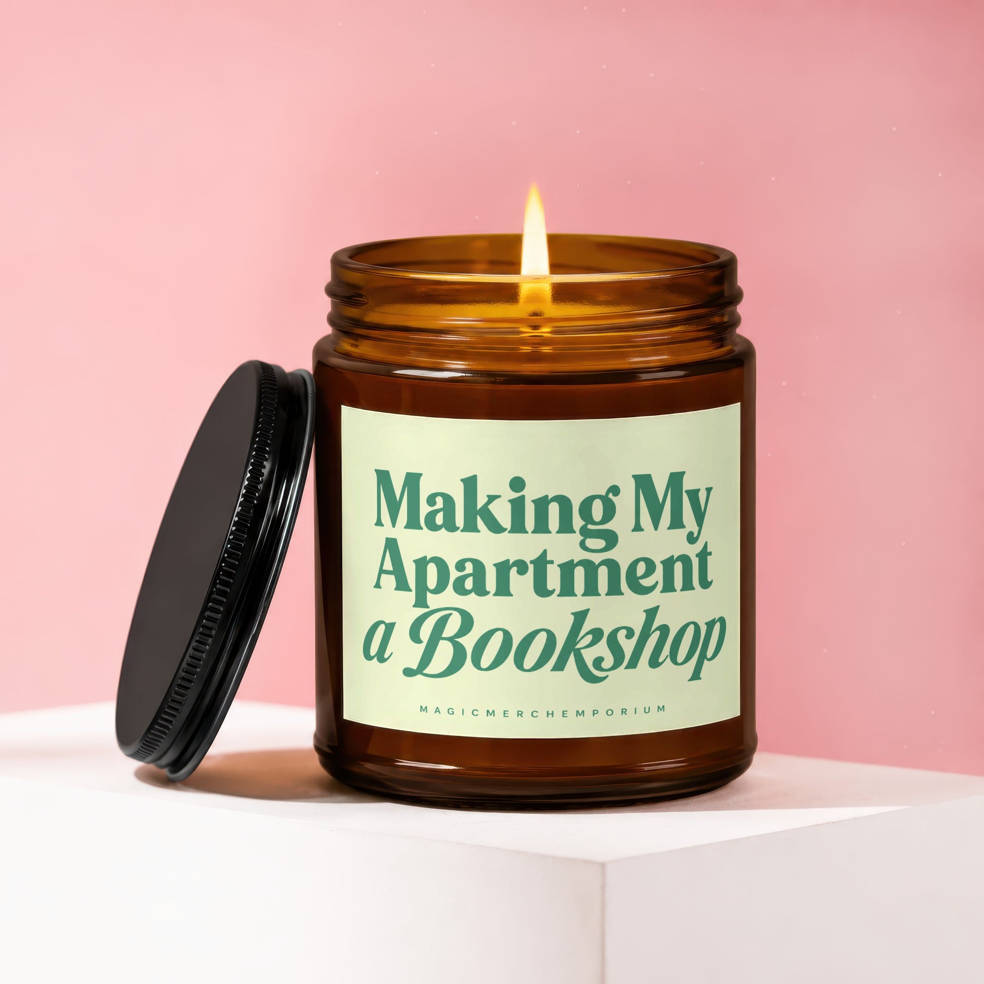 Lit amber glass candle with black lid, text "Making My Apartment a Bookshop"