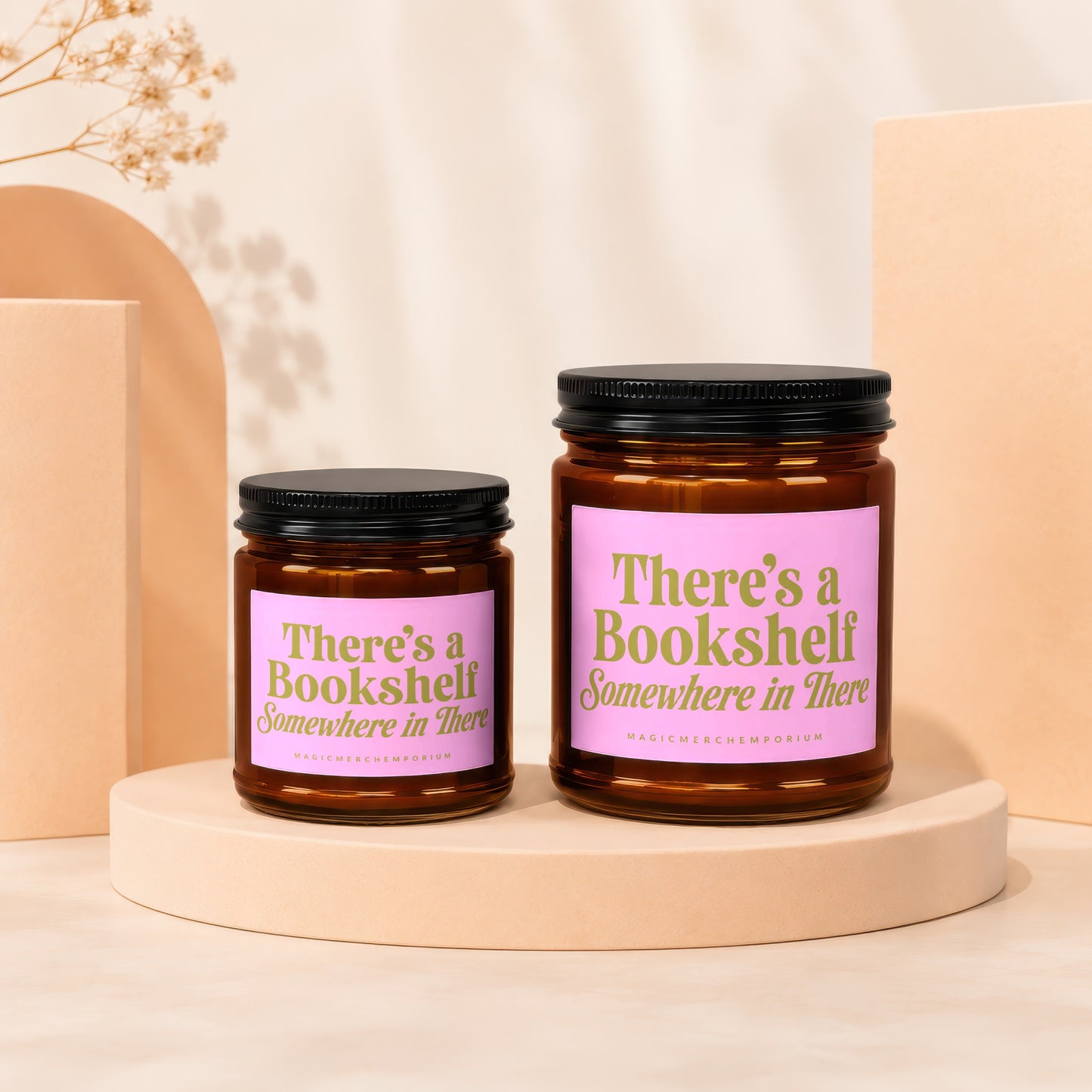 Two amber glass candles with pink labels reading "There's a Bookshelf Somewhere in There".