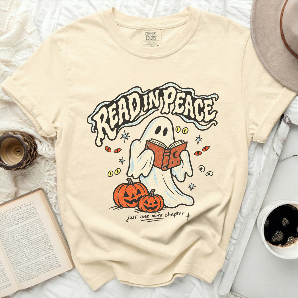 Ghost reading a book with pumpkins and text "Read in Peace".