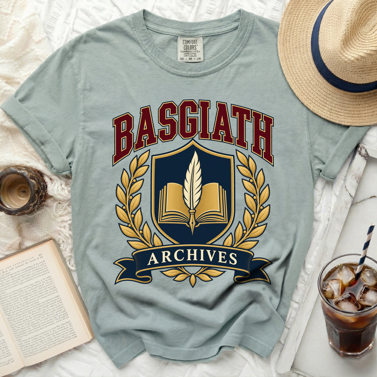 Light blue t-shirt with "Basgiath Archives" crest and open book graphic.