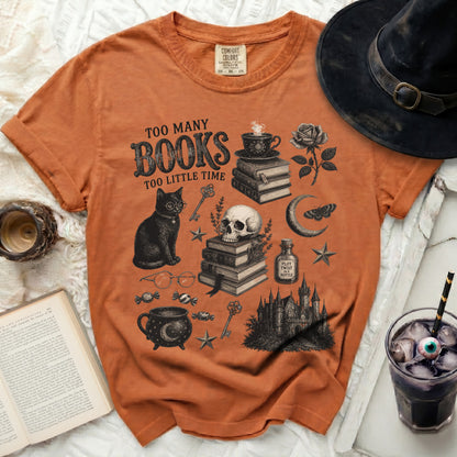 Orange t-shirt with "Too Many Books Too Little Time" graphic, black cat, skull, and gothic castle.