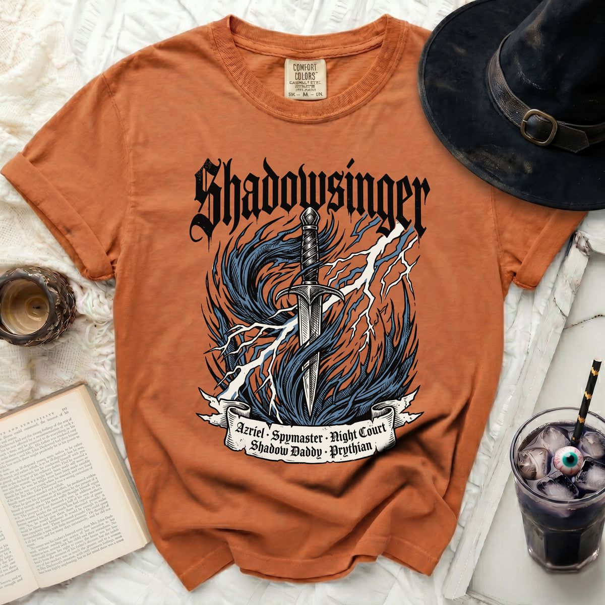 Orange t-shirt with "Shadowsinger" graphic, sword, flames, and text.