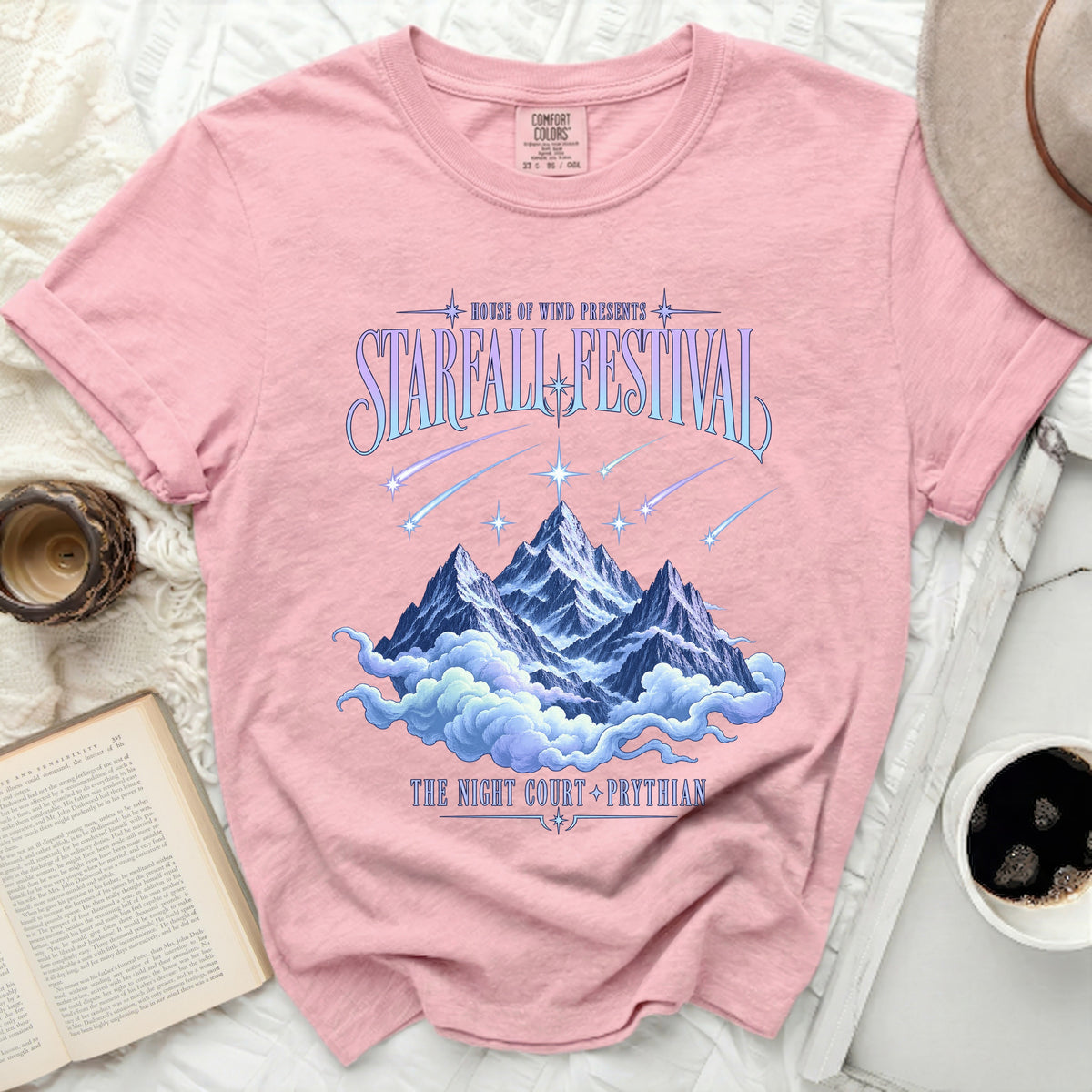 Pink shirt with "Starfall Festival" graphic featuring mountains, clouds, and shooting stars.