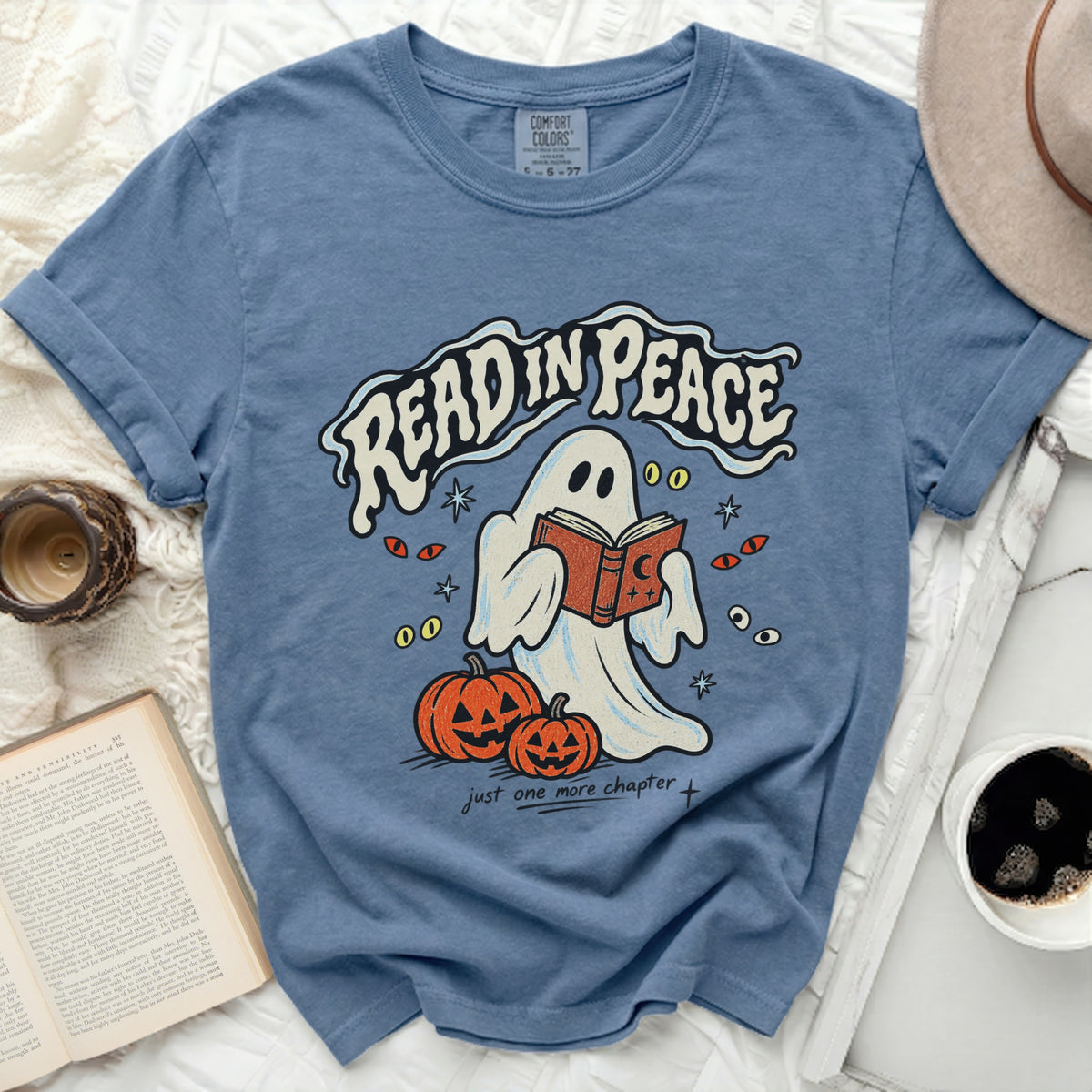 Blue t-shirt with ghost reading a book, pumpkins, and text "READ IN PEACE".