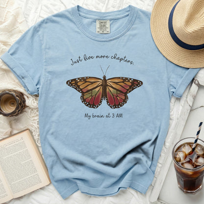 Light blue t-shirt with butterfly graphic and text "Just five more chapters. My brain at 3 AM."