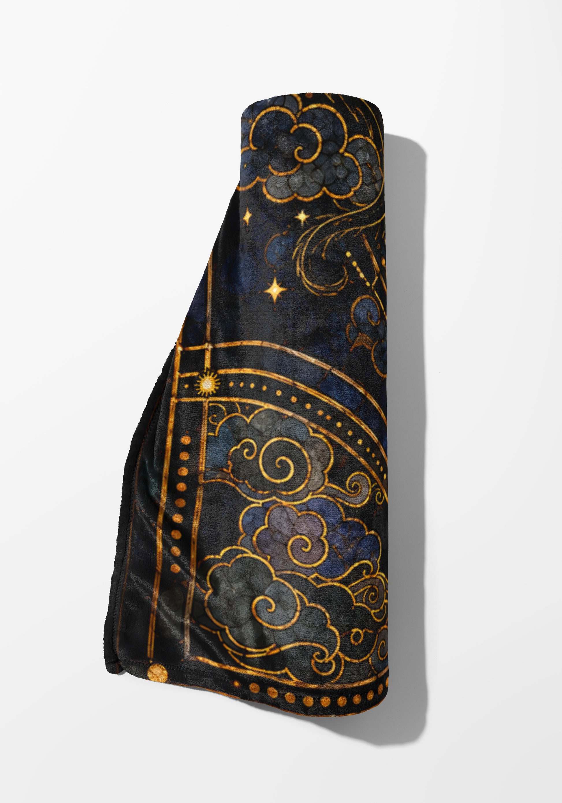 Rolled blanket with dark blue celestial pattern and gold accents.