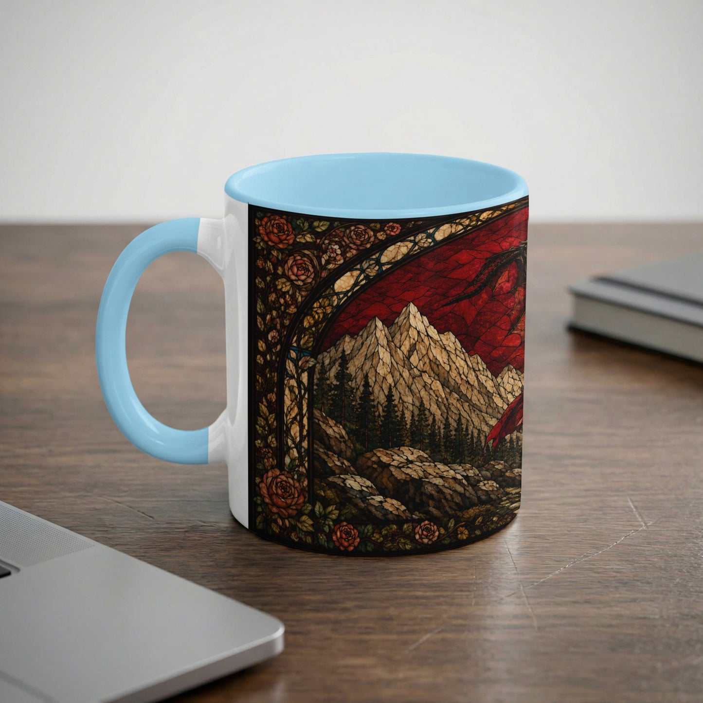 White mug with blue handle featuring stained glass dragon, mountains, and roses design.