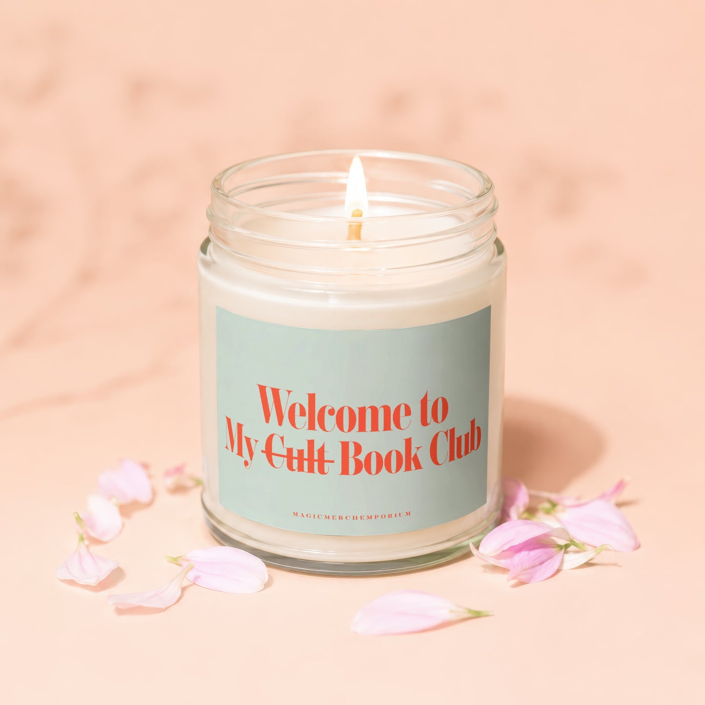 Burning candle in glass jar with "Welcome to My Cult Book Club" text.