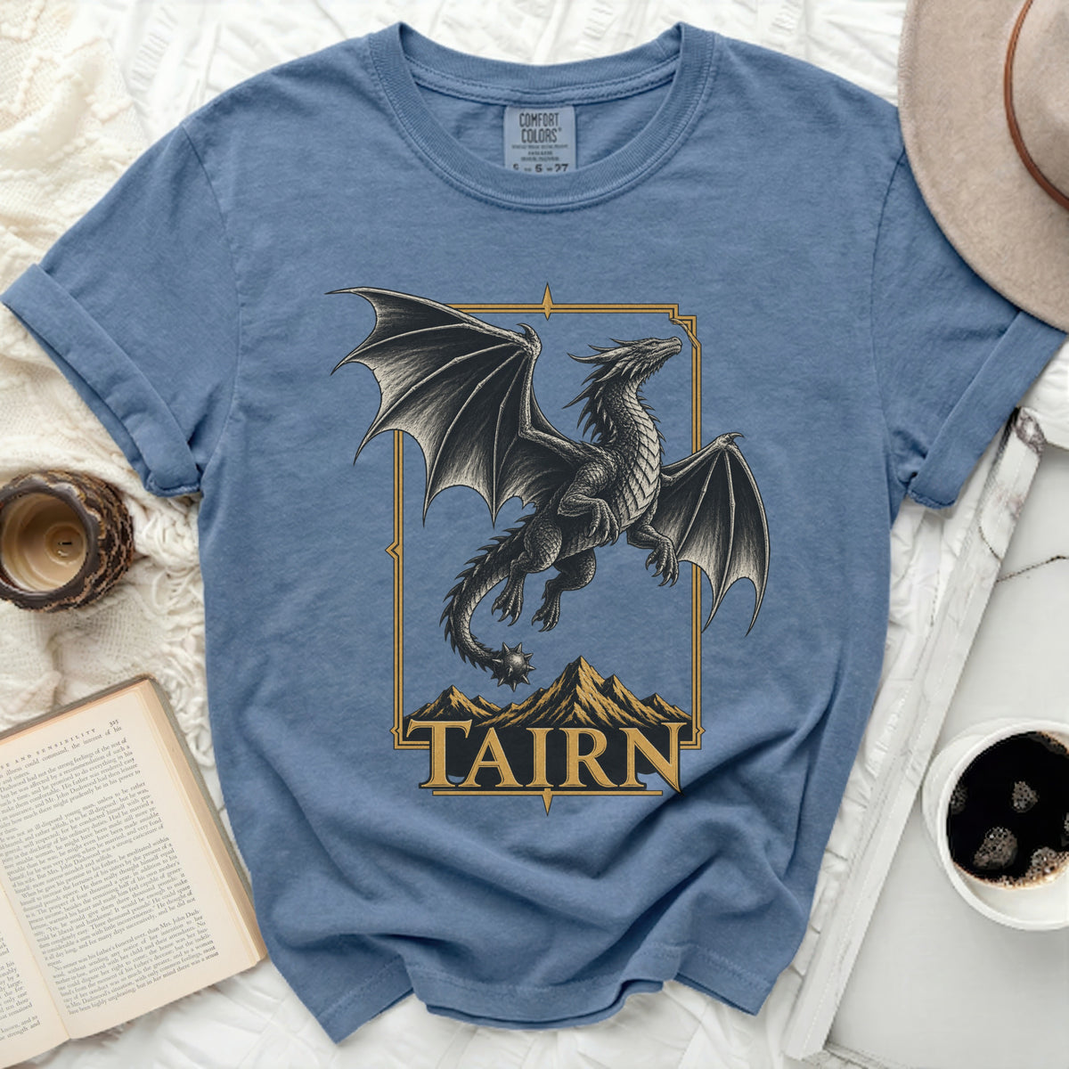 Blue t-shirt with black dragon design over mountains and "TAIRN" text.
