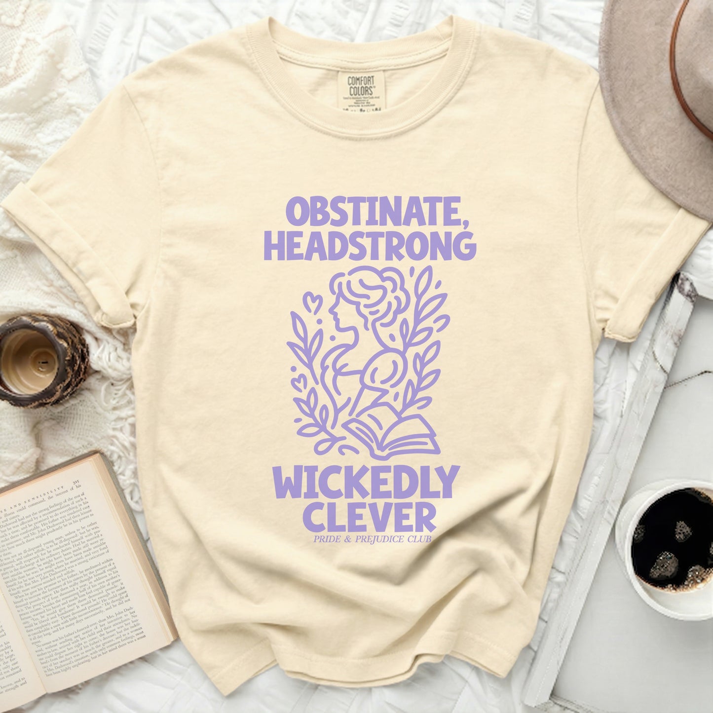 Cream t-shirt with purple text "OBSTINATE, HEADSTRONG WICKEDLY CLEVER".
