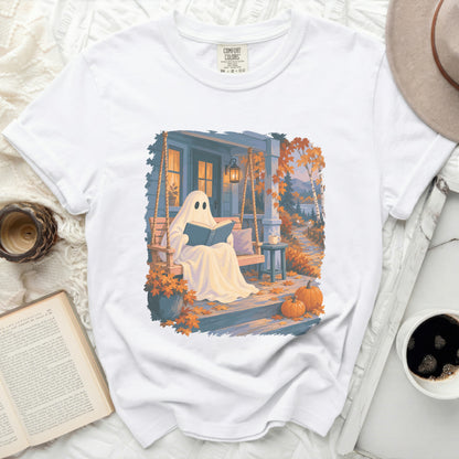 Ghost reading on a porch swing with pumpkins and fall leaves.