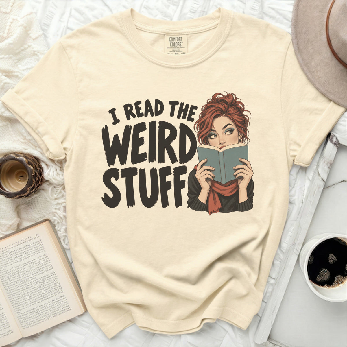 Cream t-shirt with "I READ THE WEIRD STUFF" graphic and woman reading