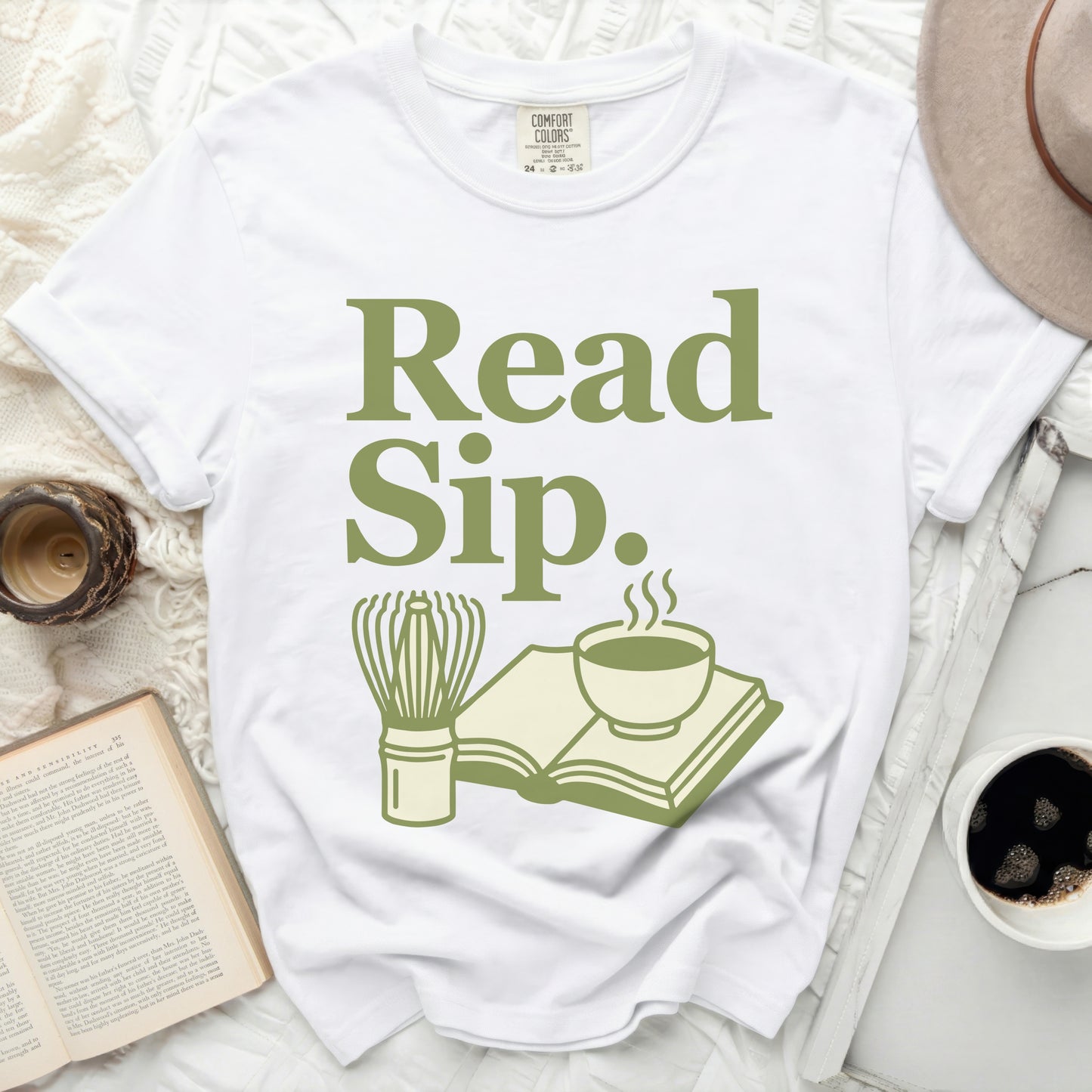 White Comfort Colors t-shirt with green text "Read Sip." and graphics.