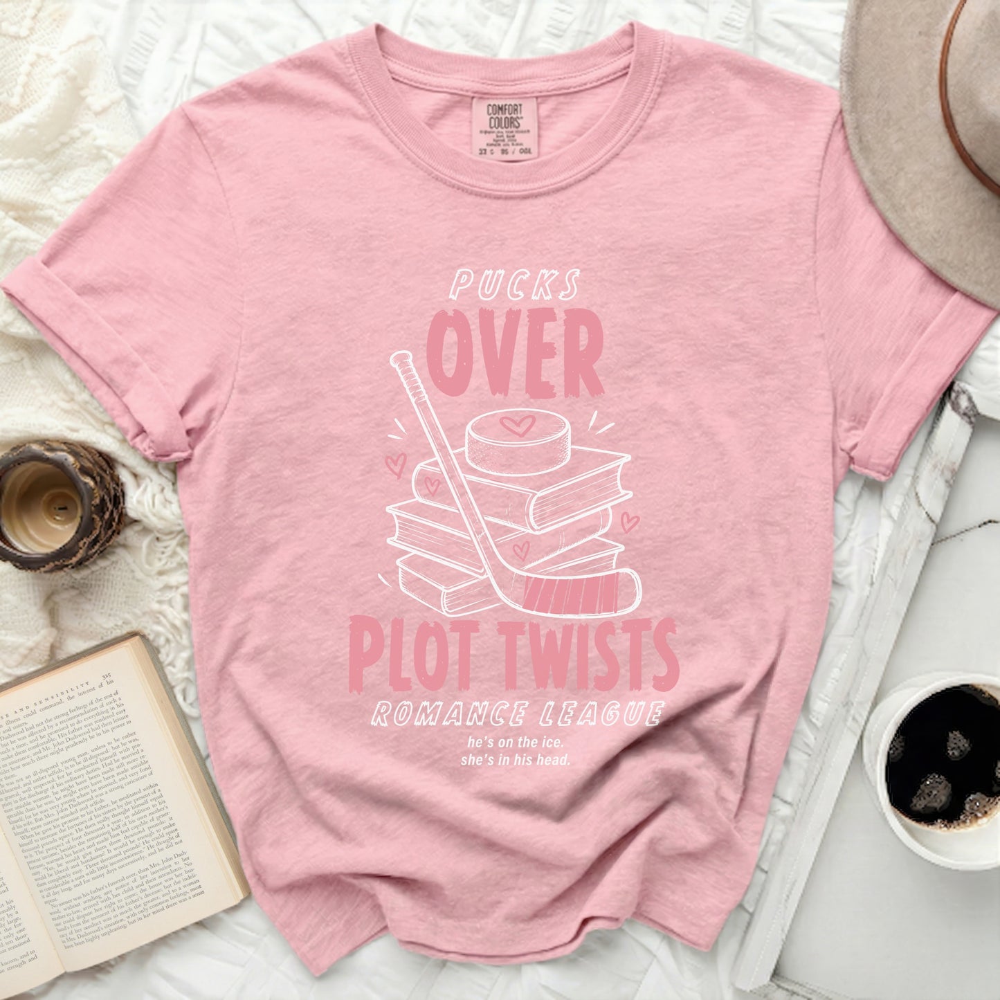 Pink t-shirt with "Pucks Over Plot Twists Romance League" and hockey graphic.