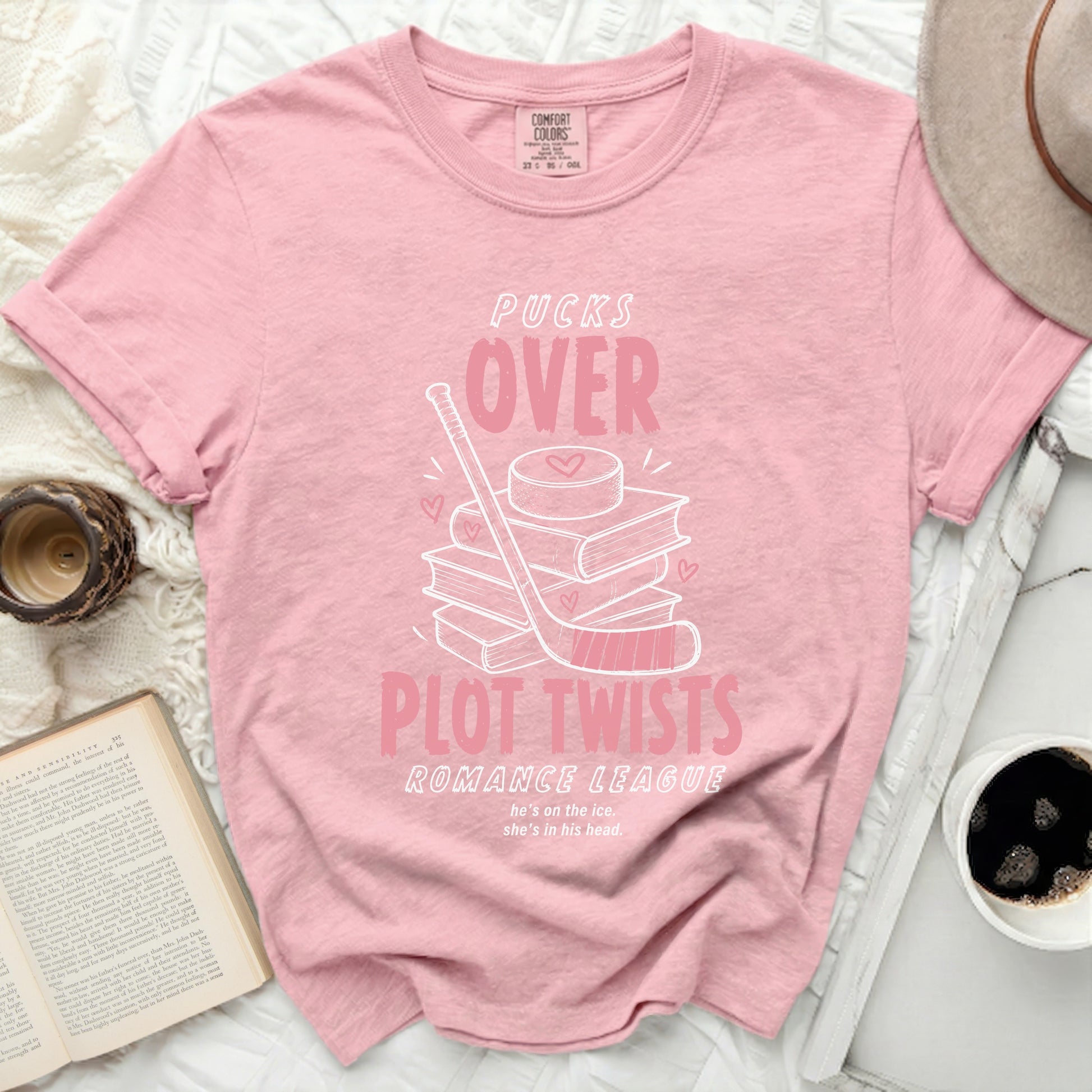 Pink t-shirt with "Pucks Over Plot Twists Romance League" and hockey graphic.