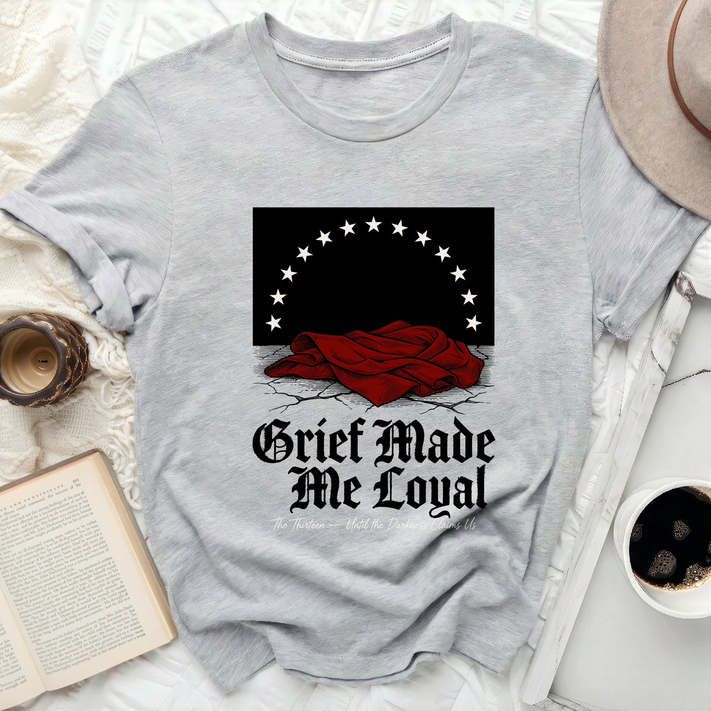 Grey t-shirt with "Grief Made Me Loyal" text and graphic.