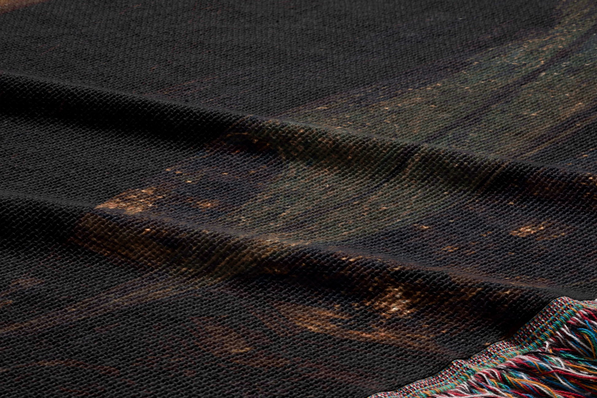 a close-up view of a dark-colored fabric with a textured pattern, possibly a blanket or textile.