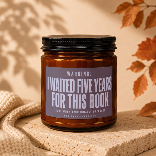 Amber candle with black lid labeled "WARNING: I WAITED FIVE YEARS FOR THIS BOOK"