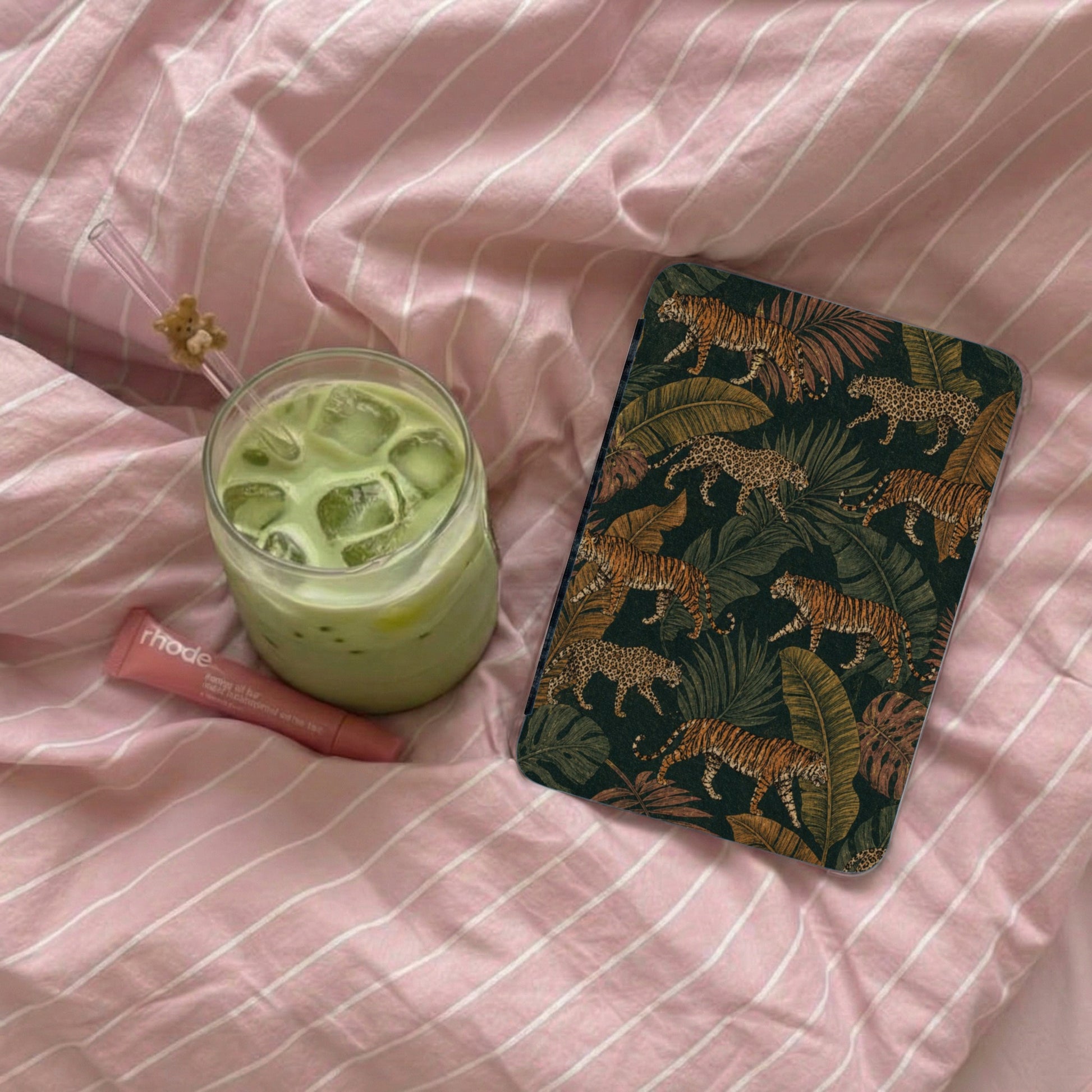 Phone case with tiger and leopard print on dark green background.