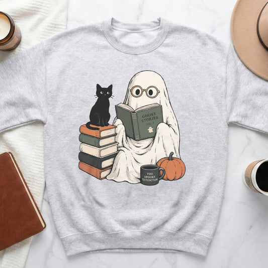 Ghost reading "Ghost Stories" with black cat, pumpkin, and "Too Spooky" mug.
