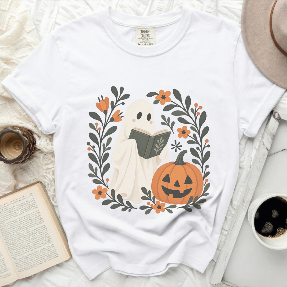 White t-shirt with a ghost, pumpkin, and floral design for Halloween.