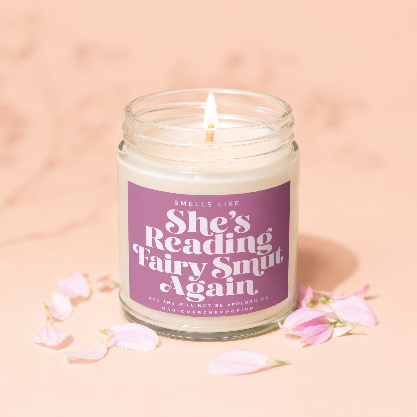 Scented candle with "She's Reading Fairy Smut Again" and "MagicMerchEmporium" text.