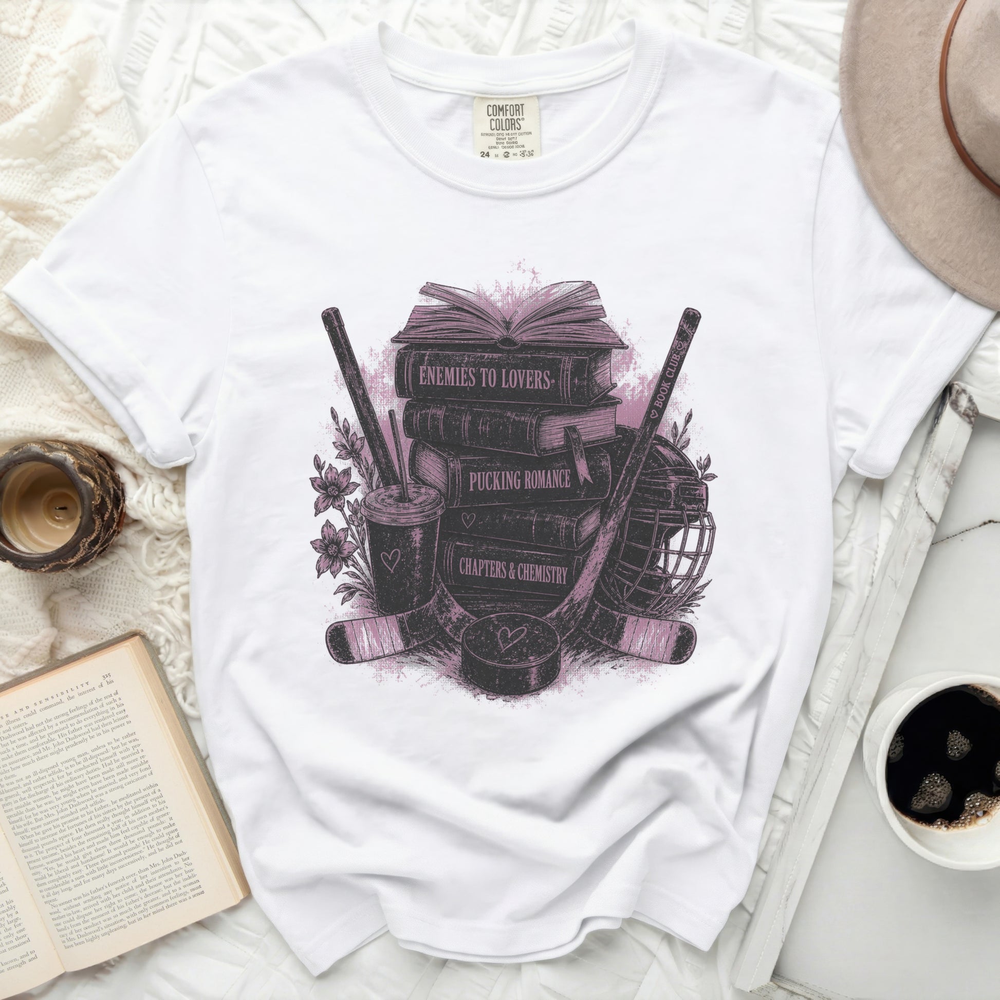 White t-shirt with "Enemies to Lovers" design featuring books and hockey gear.