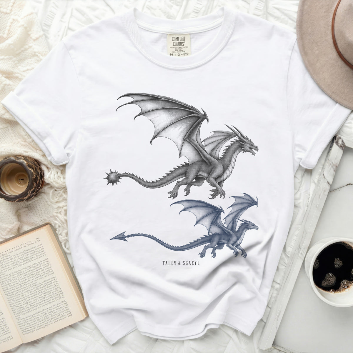 White t-shirt featuring two graphite dragon illustrations and "TAIRN & SGAEYL" text.