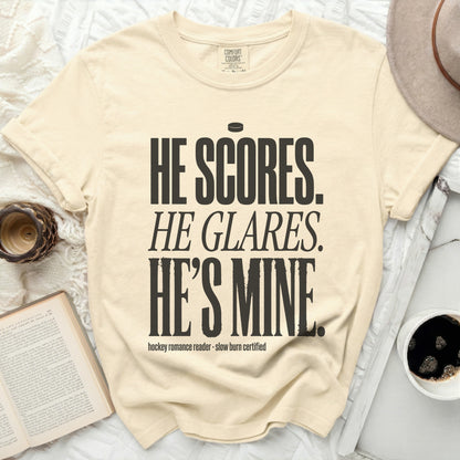 Cream t-shirt with bold black text reading "HE SCORES. HE GLARES. HE'S MINE."