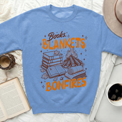 Blue sweatshirt with "Books. Blankets. Bonfires." graphic and autumn motifs.