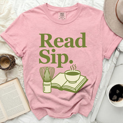 Pink t-shirt with "Read Sip." text and graphic of book, teacup, and whisk.