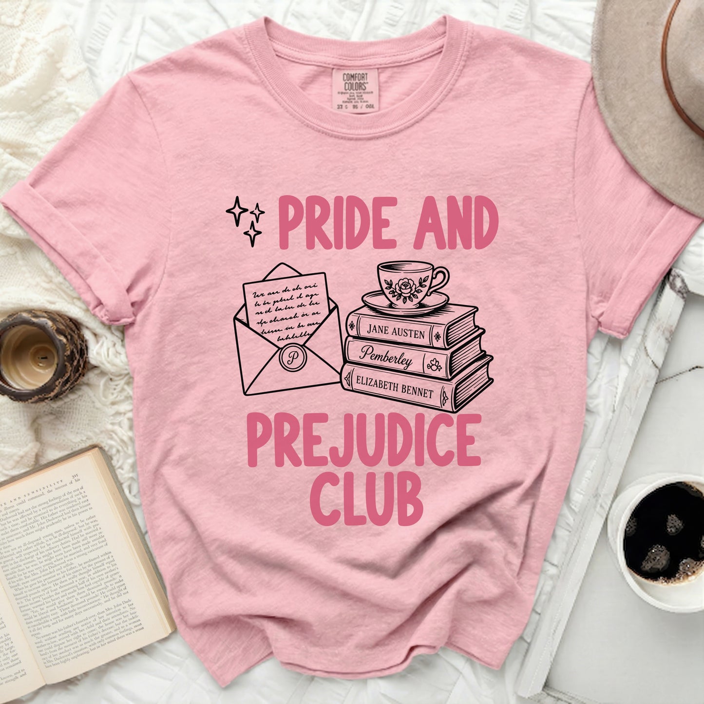Pink t-shirt with "Pride and Prejudice Club" text and literary illustrations.