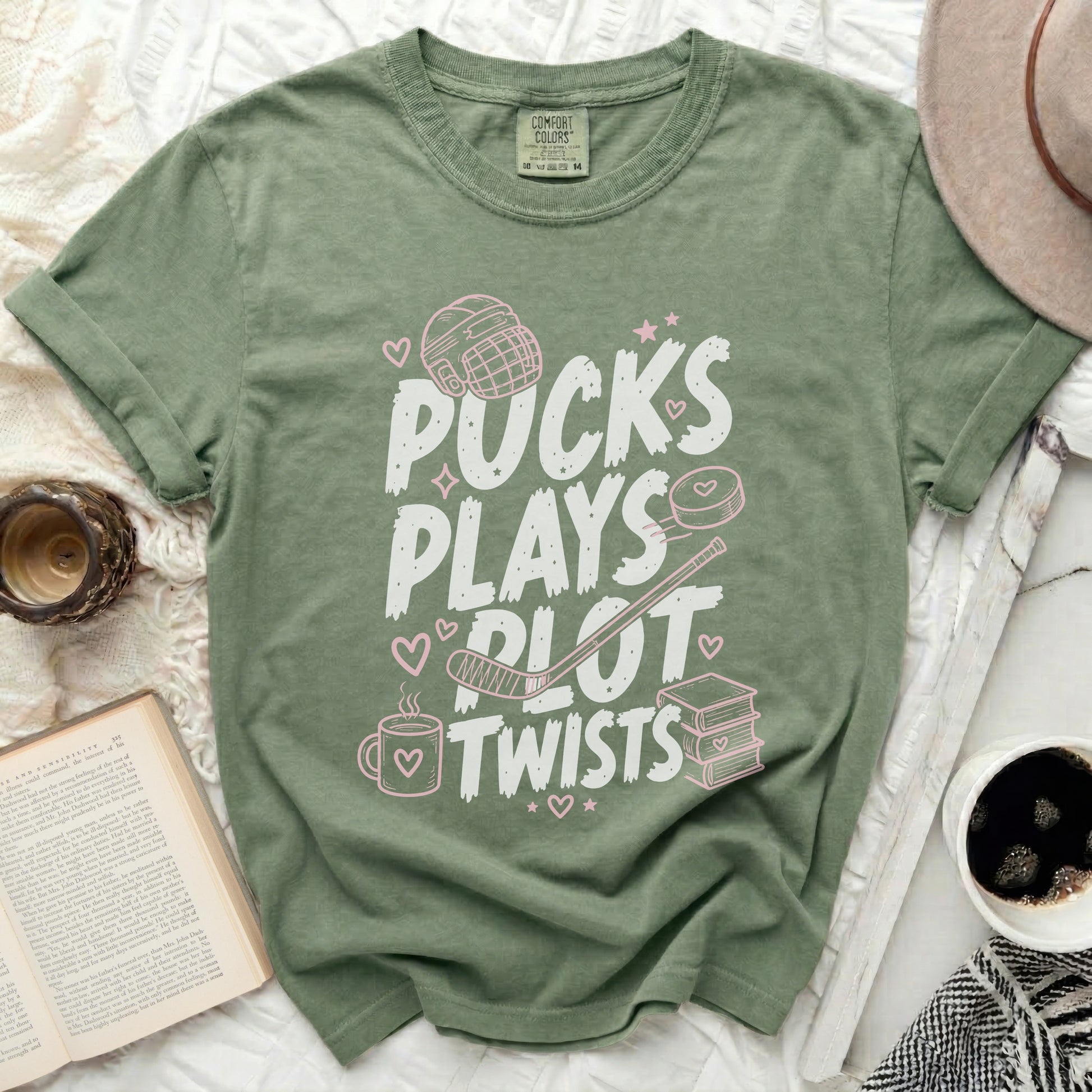 Green t-shirt with "Pucks Plays Plot Twists" in pink text.
