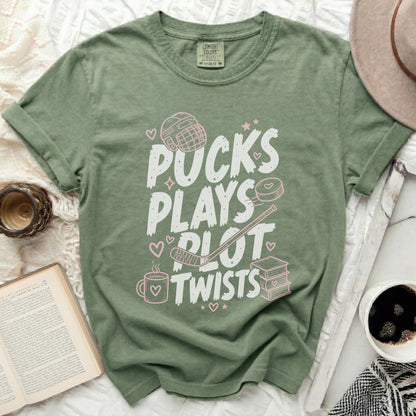 Green t-shirt with "Pucks Plays Plot Twists" in pink text.