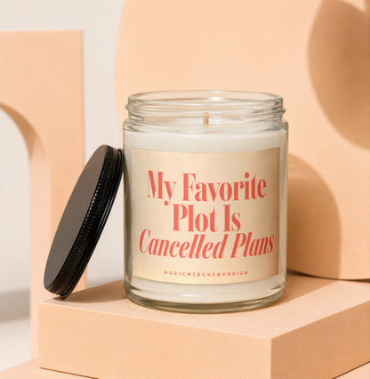 Glass candle with black lid features a label reading "My Favorite Plot Is Cancelled Plans".