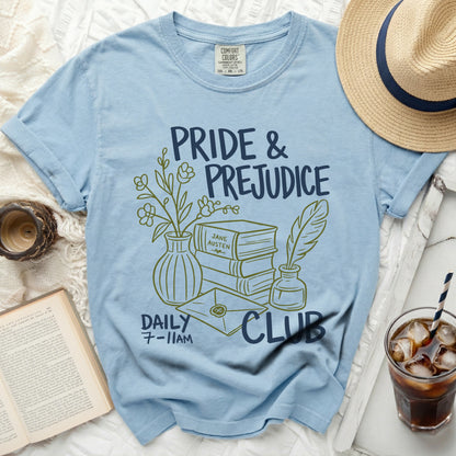 Light blue t-shirt with "Pride & Prejudice Daily 7-11AM Club" text and illustration.